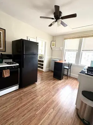 a kitchen with a black refrigerator and a table at The Bushnell Suite C2 in Hartford