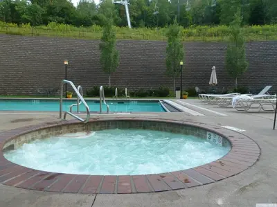 a large swimming pool with a brick wall at Slopeside Ski-In/Ski-Out ; HotTub ; 2 Room 2 Bath in Hunter