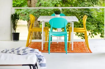 a table and four chairs on a porch with a plant on it at 1850 Catskills Farmhouse on 8 acres in E. Durham in East Durham