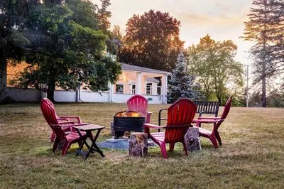 a group of four chairs around a fire pit at 1850 Catskills Farmhouse on 8 acres in E. Durham in East Durham