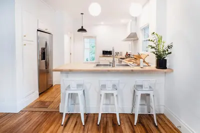 a kitchen with a counter with three bar stools at 1850 Catskills Farmhouse on 8 acres in E. Durham in East Durham