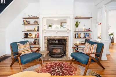 a living room with two chairs and a fireplace at 1850 Catskills Farmhouse on 8 acres in E. Durham in East Durham