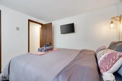 a bedroom with a bed with a camera on it at Camp Cedar:7 miles to Camelback, 5 to Kalahari! in Long Pond