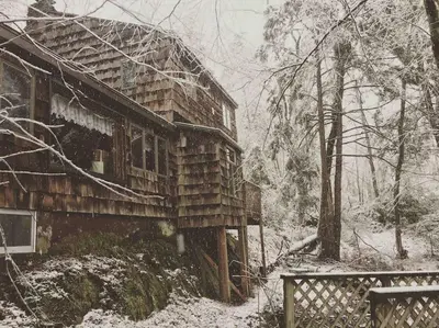 an old wooden house with snow on it at Peaceful Gateway to Island Creek Cottage in East Stroudsburg