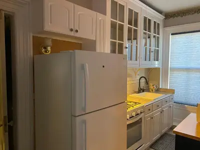 a kitchen with white cabinets and a refrigerator at 1 Br Private Victorian Apt in convenient City location on half acre sleeps 4 in Poughkeepsie