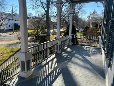 a porch of a house with a white fence at 1 Br Private Victorian Apt in convenient City location on half acre sleeps 4 in Poughkeepsie
