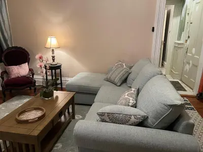 a living room with a couch and a coffee table at 1 Br Private Victorian Apt in convenient City location on half acre sleeps 4 in Poughkeepsie