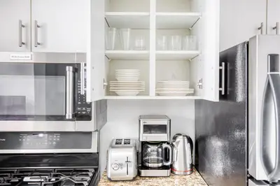a kitchen with white cabinets and white appliances at Tribeca Studio Indoor pool Great views NYC-185 in New York