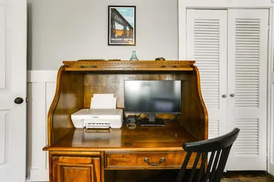 a wooden desk with a television and a printer at Bright Cornwall-On-Hudson Vacation Rental! in Cornwall-on-Hudson