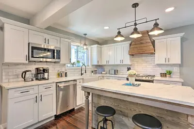 a kitchen with white cabinets and a large island at Bright Cornwall-On-Hudson Vacation Rental! in Cornwall-on-Hudson
