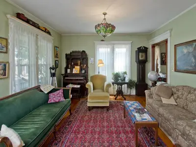 a living room with a green couch and a table at Blooming Inn Shelburne Falls in Shelburne Falls