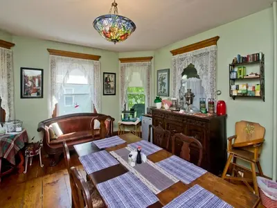 a dining room with a table and a chair at Blooming Inn Shelburne Falls in Shelburne Falls