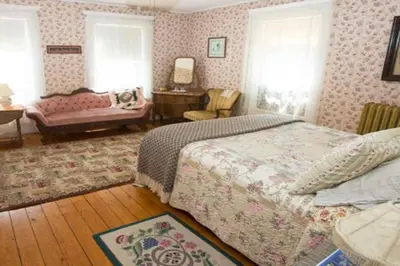 a bedroom with a bed and a table and a couch at Blooming Inn Shelburne Falls in Shelburne Falls