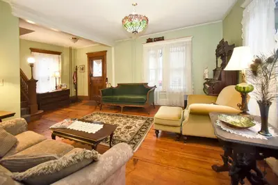 a living room with a couch and a piano at Blooming Inn Shelburne Falls in Shelburne Falls