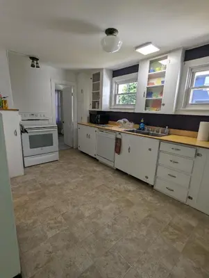 a kitchen with white cabinets and a stove top oven at Blooming Inn Shelburne Falls in Shelburne Falls