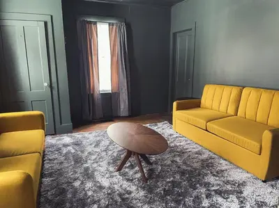a living room with a yellow couch and a table at The Brookside Lodge & Cottage in Dover