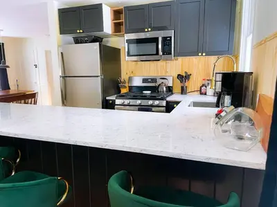 a kitchen with black cabinets and a white counter top at The Brookside Lodge & Cottage in Dover