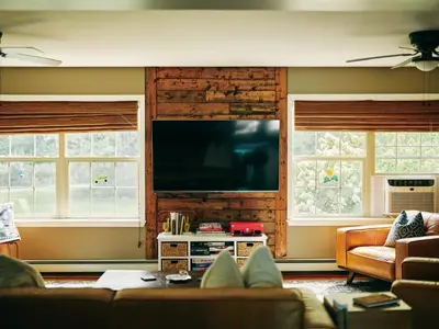 a living room with a couch and a flat screen tv at Bear House Catskills - Private Pool, Pond, Hot Tub, Work-Friendly in Cairo