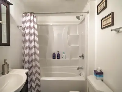 a white bathroom with a shower and a sink at 1st Base Apt 1 All Star Baseball Rentals in Oneonta