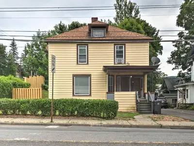 a yellow house on the side of a street at 1st Base Apt 1 All Star Baseball Rentals in Oneonta