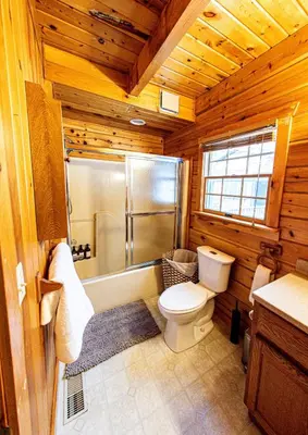a wooden bathroom with a toilet and a shower at Log Home w Mountain Views Near Windham & Hunter Ski Resorts in Maplecrest