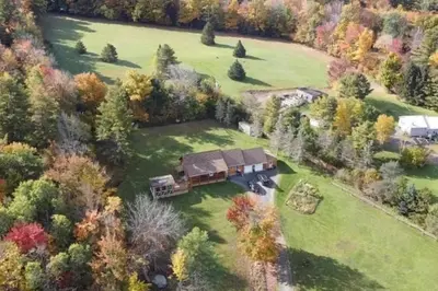 an aerial view of a house in a field at Log Home w Mountain Views Near Windham & Hunter Ski Resorts in Maplecrest