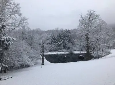 a snow covered field with trees and a fence at NEWLY REMODELED FOUR BEDROOM All SEASON CONDO W MOUNTAIN VIEWS in East Jewett