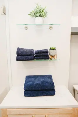 a bathroom with three blue towels on a counter at NEWLY REMODELED FOUR BEDROOM All SEASON CONDO W MOUNTAIN VIEWS in East Jewett