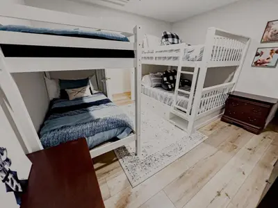 a bedroom with two bunk beds and a crib at NEWLY REMODELED FOUR BEDROOM All SEASON CONDO W MOUNTAIN VIEWS in East Jewett
