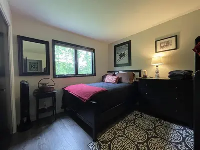 a bedroom with a bed and a dresser and a window at Mountain Condo with Modern Cabin Style in East Jewett
