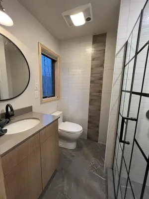 a bathroom with a toilet and a sink and a mirror at Mountain Condo with Modern Cabin Style in East Jewett