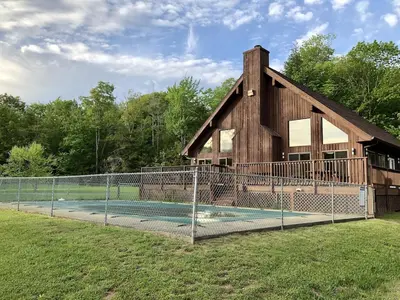 a house with a swimming pool with a fence at Mountain Condo with Modern Cabin Style in East Jewett