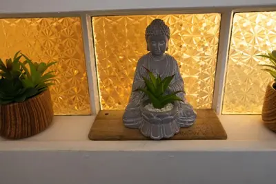 a statue sitting on a shelf next to two potted plants at Cozy Tiny Haus Apt in Torrington