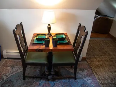 a table with two chairs and a lamp on it at Cozy Tiny Haus Apt in Torrington