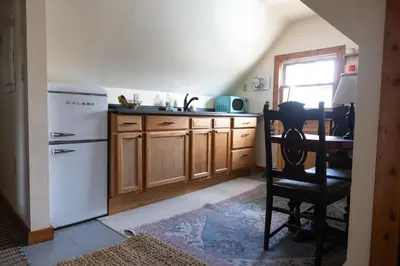 a kitchen with a white refrigerator and wooden cabinets at Cozy Tiny Haus Apt in Torrington