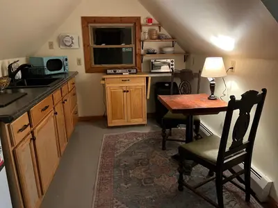 a small kitchen with a table and a desk with a television at Cozy Tiny Haus Apt in Torrington