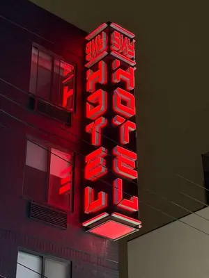 a red neon sign on the side of a building at Sky Hotel Flushing/Laguardia Airport in Queens