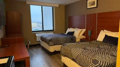 a hotel room with two beds and a window at Sky Hotel Flushing/Laguardia Airport in Queens