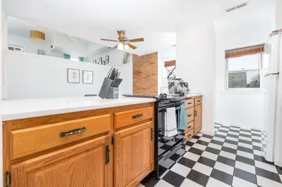 a kitchen with a black and white checkered floor at Exquisite Downtown Loft Apartment in Hartford