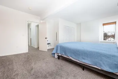 a white bedroom with a bed and a window at Exquisite Downtown Loft Apartment in Hartford