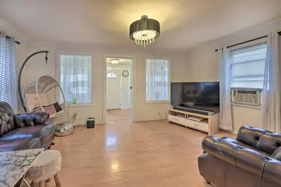 a living room with a couch and a flat screen tv at Charming New York Escape Near Central Park! in Jericho