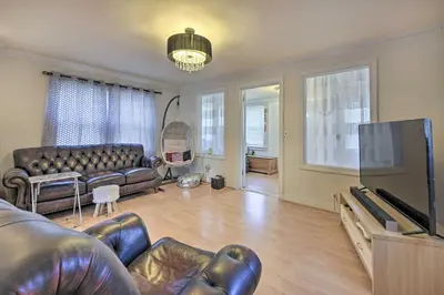 a living room with a couch and a flat screen tv at Charming New York Escape Near Central Park! in Jericho