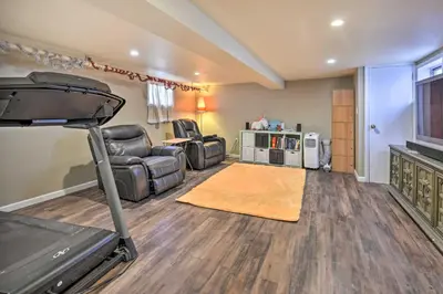 a living room with a treadmill and a room with a couch at Charming New York Escape Near Central Park! in Jericho
