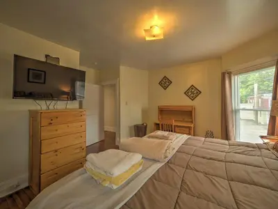 a bedroom with a large bed with a dresser and a window at 1st Base Apt 2 All Star Baseball Rentals in Oneonta