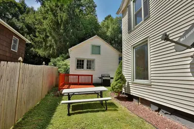 a bench in a yard next to a house at The Hill All Star Baseball Rentals in Oneonta