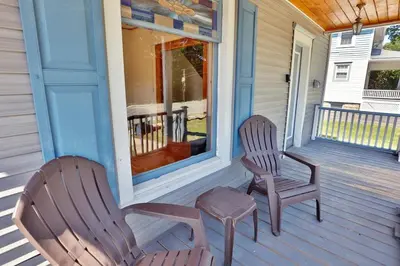 two chairs and a stool on the front porch of a house at The Wheelhouse All Star Baseball Rentals in Oneonta