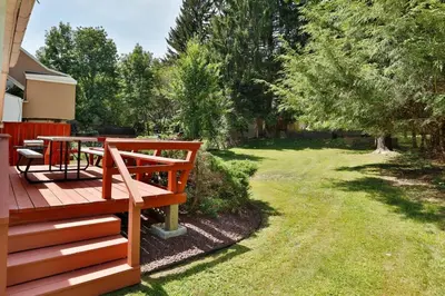 a wooden deck with a table in a yard at The Wheelhouse All Star Baseball Rentals in Oneonta
