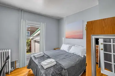 a bedroom with a large bed and a window at The Wheelhouse All Star Baseball Rentals in Oneonta
