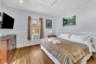 a bedroom with a bed and a flat screen tv at 2nd Base Apt 1 All Star Baseball Rentals in Oneonta