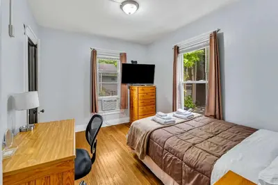 a bedroom with a bed and a desk and a television at 2nd Base Apt 1 All Star Baseball Rentals in Oneonta